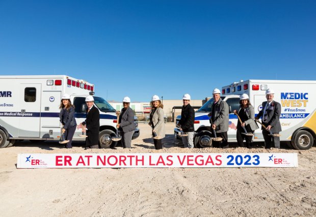 El grupo posa quién arrojó tierra en la inauguración de Valley ER en North Las Vegas frente al letrero que dice que llegará a fines de 2023