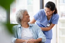Nurse smiling at a patient in a wheelchair