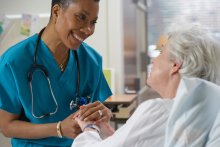 Nurse holding a patient's hand