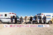 Group poses who tossed dirt on groundbreaking for Valley ER at North Las Vegas in front of sign that says coming late 2023