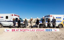 Group poses who tossed dirt on groundbreaking for Valley ER at North Las Vegas in front of sign that says coming late 2023